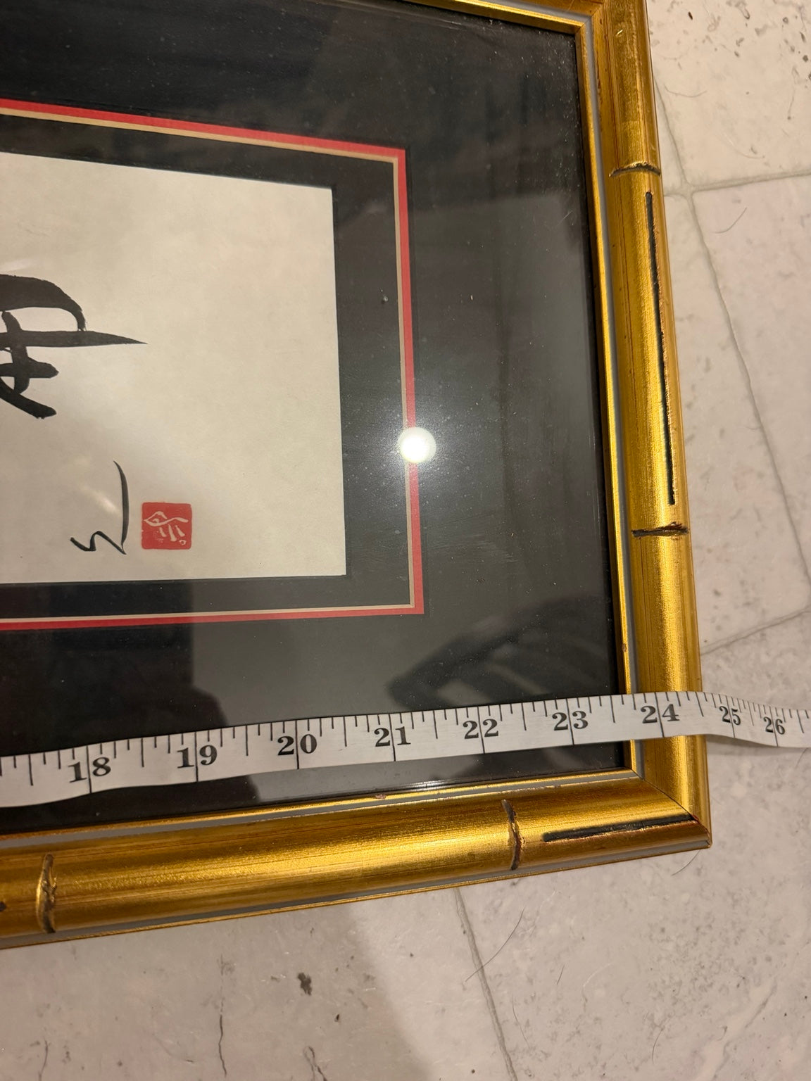 Detail of gold bamboo-style frame, matting and measuring tape